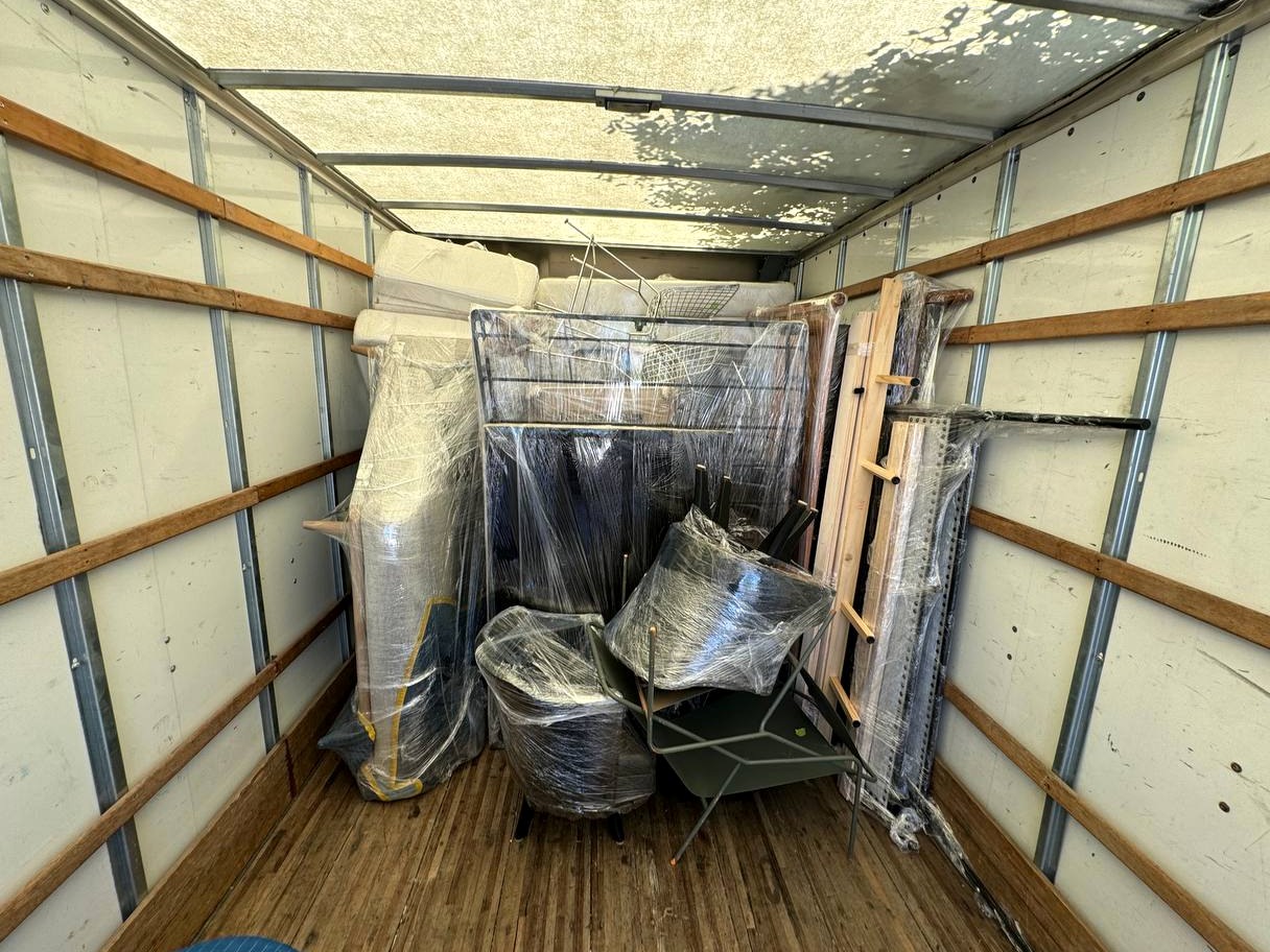 Organized moving truck interior with wrapped items secured inside